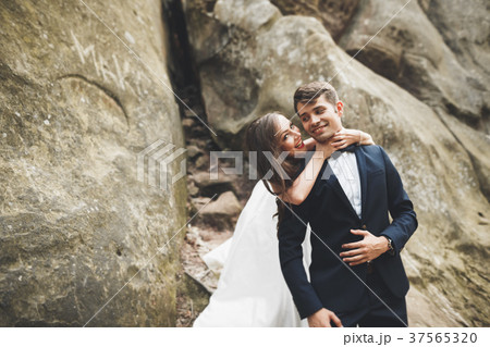 Gorgeous bride, groom kissing and hugging near the 37565320