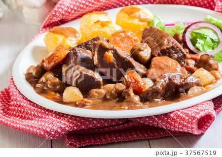Beef Bourguignon stew served with baked potatoes Beef Bourguignon stew served with baked potatoes 37567519