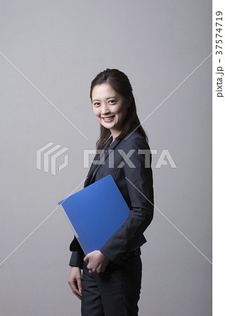 Young woman in a suit with files - Stock Photo [37574719] - PIXTA