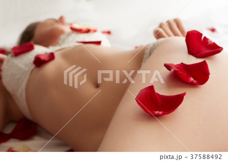 Rose petals on hip of sexy lingerie model 37588492