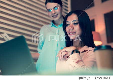 Pleasant female boss checking work of her 37591683