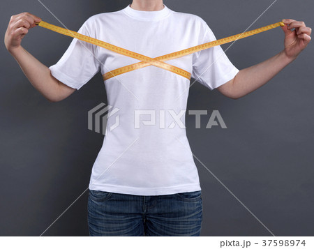 A girl with a small chest and a centimeter tape. A girl with a small chest and a centimeter tape. 37598974
