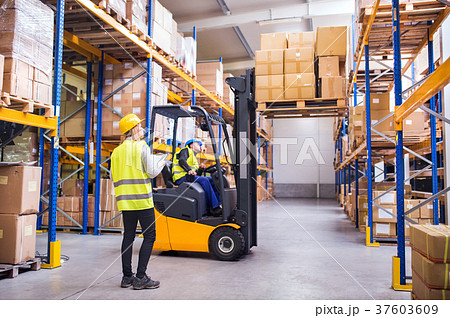 Young warehouse workers working together. Young warehouse workers working together. 37603609