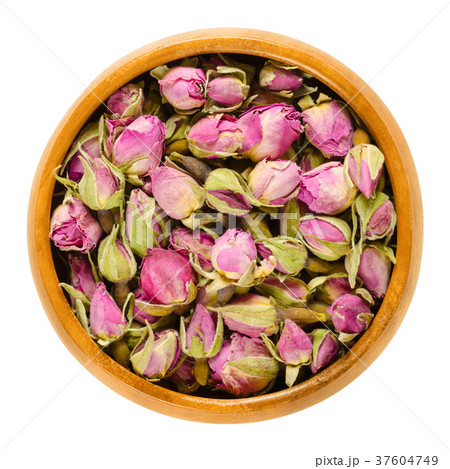 Dried rose buds in wooden bowl over white 37604749