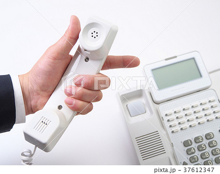 受話器を持って指差しをするビジネスマンの写真素材