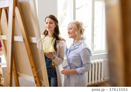 artists discussing painting on easel at art school artists discussing painting on easel at art school 37613503