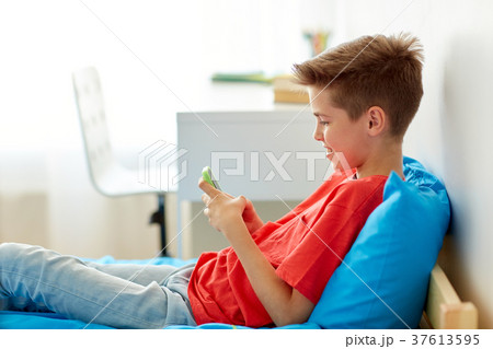 happy smiling boy with smartphone at home happy smiling boy with smartphone at home 37613595