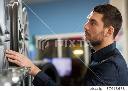 male customer choosing wheel rims at car service male customer choosing wheel rims at car service 37613678