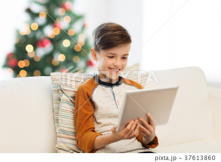 smiling boy with tablet pc at home at christmas 37613860