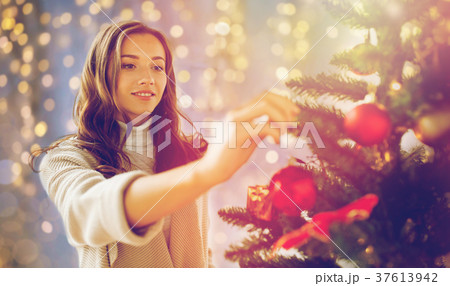 happy young woman decorating christmas tree 37613942