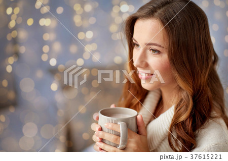 happy woman with cup of cocoa or coffee at home 37615221