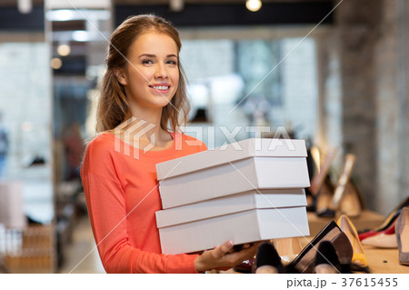 woman or shop assistant with shoe boxes at store woman or shop assistant with shoe boxes at store 37615455