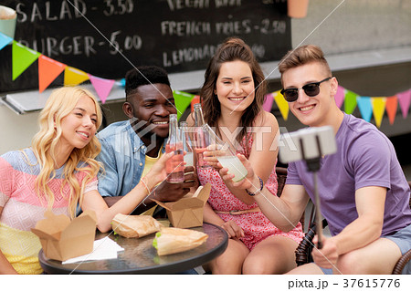 happy young friends taking selfie at food truck happy young friends taking selfie at food truck 37615776
