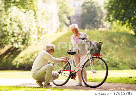 happy senior couple with bicycle at summer park 37615795