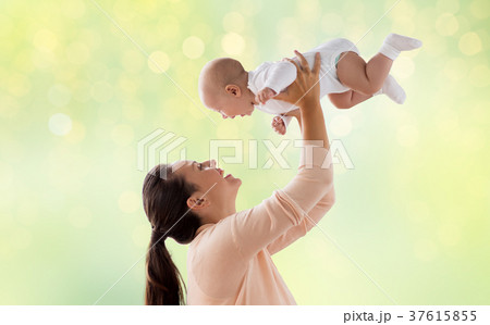 happy mother playing with little baby over green 37615855