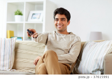 man with remote control watching tv at home 37615991