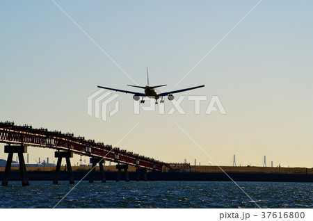 海上の誘導灯と西日に輝く着陸態勢の旅客機　b-2 ウィングレット無し　明るめ 37616800