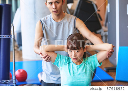 スポーツジムで運動する女性とトレーナー 37618922