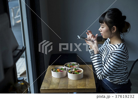 カフェで食べ物を撮影する女性 カフェで食べ物を撮影する女性 37619232