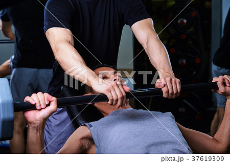 スポーツジムで運動する男性とトレーナー 37619309