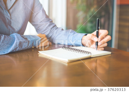 Woman hand is writing on notepad with pen. 37620313