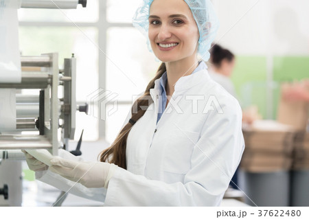 Happy employee wearing lab coat while handling 37622480