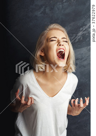 Screaming young woman at gray background Screaming young woman at gray background 37622979