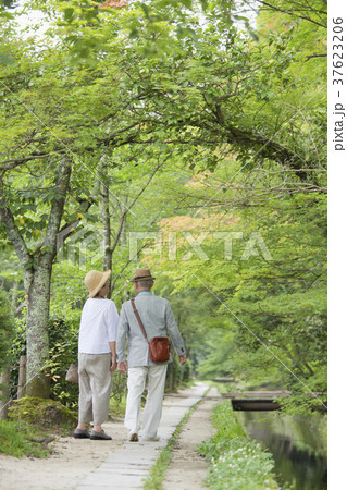 川沿いの遊歩道を歩くシニア夫婦 37623206