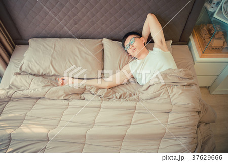 Depressed Asian man blaming on the phone on bed Depressed Asian man blaming on the phone on bed 37629666