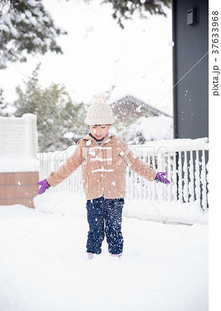 雪を舞い上げる女の子の写真素材