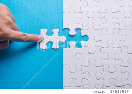 Hand holding piece of white puzzle Hand holding piece of white puzzle 37635917