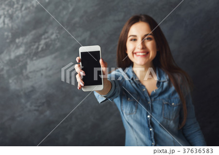 Happy girl with smartphone at black background Happy girl with smartphone at black background 37636583
