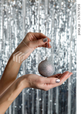 female hands holding a shiny silver ball female hands holding a shiny silver ball 37637856
