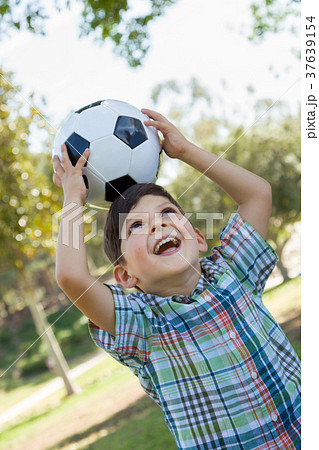 Cute Young Boy Playing with Soccer Ball Outdoors in the Park. Cute Young Boy Playing with Soccer Ball Outdoors in the Park. 37639154