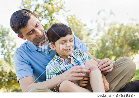 Loving Father Puts a Bandage on the Elbow of His Young Son in th 37639337