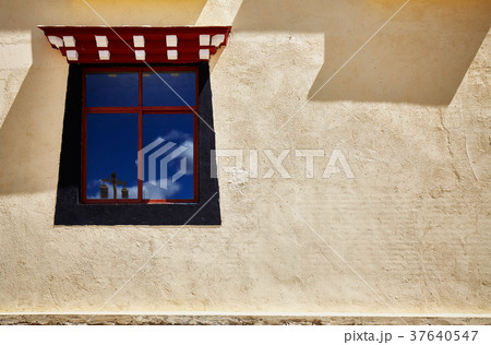 Old wall with window painted in Tibetan style. 37640547