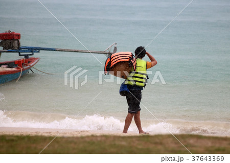 Tourists with raincoat or Life jacket on the beach Tourists with raincoat or Life jacket on the beach 37643369