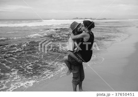 a guy and a girl are kissing on a beach a guy and a girl are kissing on a beach 37650451