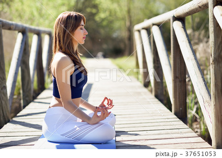Young beautiful woman doing yoga in nature Young beautiful woman doing yoga in nature 37651053