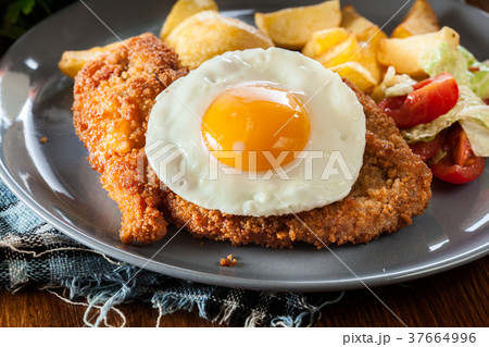 Breaded viennese schnitzel with fried agg 37664996