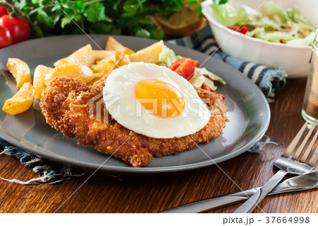 Breaded viennese schnitzel with fried agg 37664998