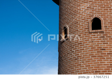 red brick block round tower with two round windows 37667251