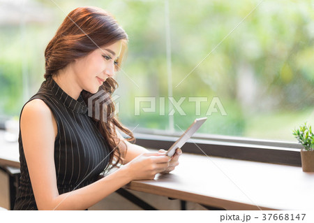 Beautiful woman smile and playing tablet. Beautiful woman smile and playing tablet. 37668147