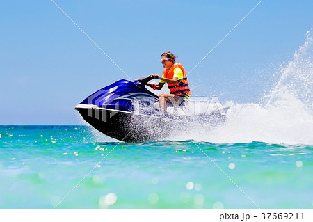 Teenager on jet ski. Teen age boy water skiing. 37669211