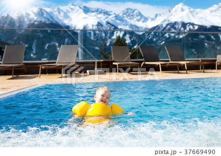 Child in outdoor swimming pool of alpine resort 37669490