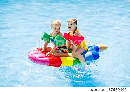 Kids on inflatable float in swimming pool. Kids on inflatable float in swimming pool. 37670495