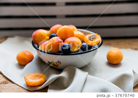Studio shot of bowl with plums and apricots 37670740
