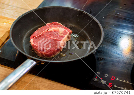 Roasting meat steak in frying pan 37670741