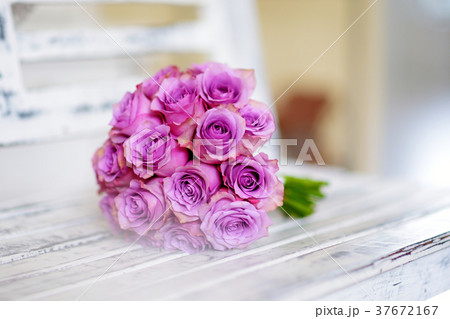 Beautiful pink bridal bouquet lying on white bench Beautiful pink bridal bouquet lying on white bench 37672167