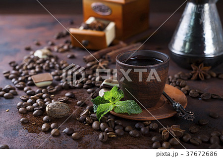 Coffee in cup and mint leaves on dark stone table. 37672686